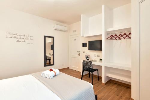 a white bedroom with a bed and a desk at Coral Bay Charming House in Alghero