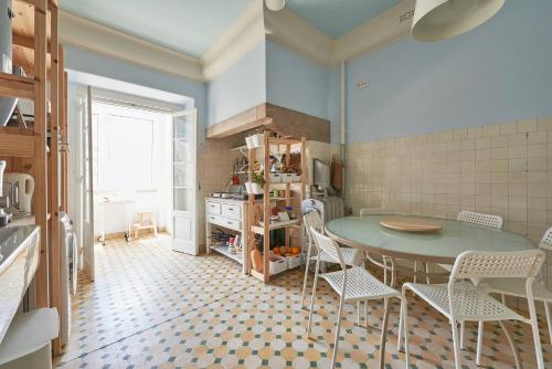 a kitchen with a table and chairs in a room at Suite's Vintage in Lisbon