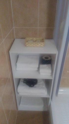a white shelf in a bathroom with towels at B&B Da Rosa Camerota in Camerota