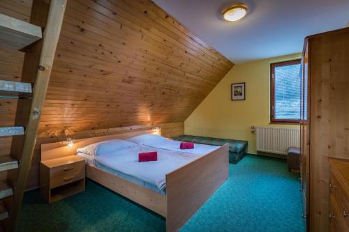 łóżko w pokoju z drewnianą ścianą w obiekcie Chalupa LUKA Terchová w Tierchowej