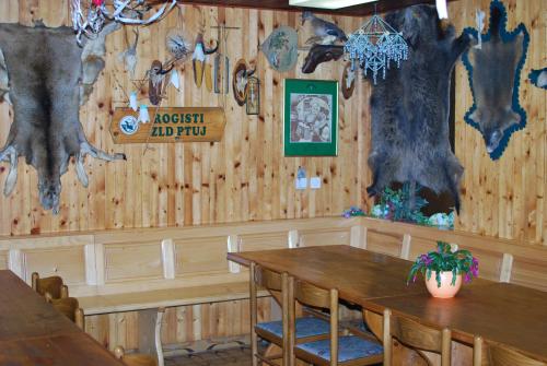 Farm Stay Bogša في Ormoz: غرفة طعام مع طاولة وجدار شجرة
