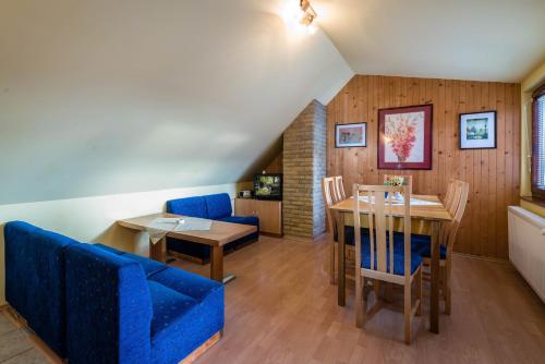 uma sala de jantar com um sofá azul e uma mesa em Chalupa LUKA Terchová em Terchová