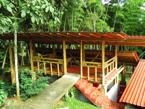 a wooden building with a bridge in a forest at Finca Hotel Guayacundo in Vergara