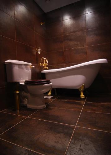a bathroom with a bath tub and a toilet at Hotel St. Barbara in Tallinn