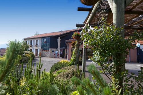 um pátio de um edifício com plantas em primeiro plano em Logis Hotel Restaurant La Tour em Dunières