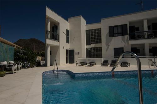 una casa con piscina frente a un edificio en Hotel La Posada De Paco - Spa & Adults Friendly, en San José