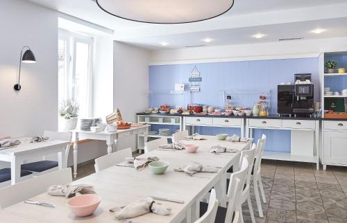 a kitchen with white tables and chairs in a room at Hotel Central Luzern in Luzern