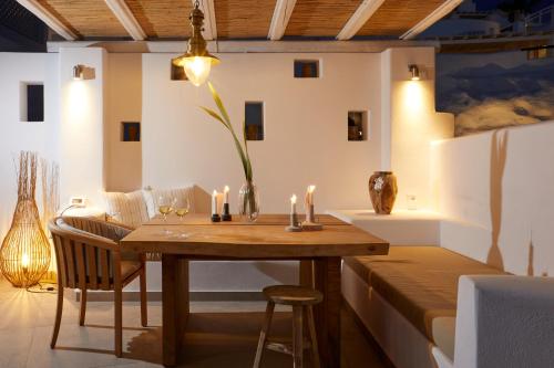 a dining room with a wooden table and candles at Volcano View by Caldera Collection in Fira