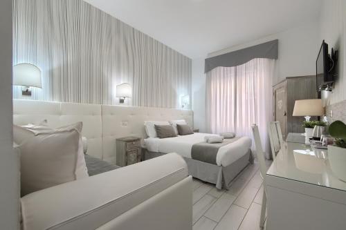 a white hotel room with two beds and a couch at Vatican's Roof in Rome