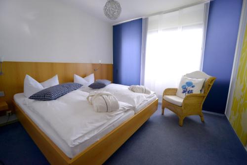 a bedroom with a large bed and a chair at BELVEDERE Appart & Chalet - Ihr Zuhause auf Zeit am Edersee - Ihr Geschenk die GästeCard GrimmHeimat in Waldeck