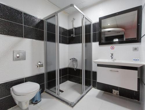y baño con ducha, aseo y lavamanos. en Ozbay Hotel, en Pamukkale