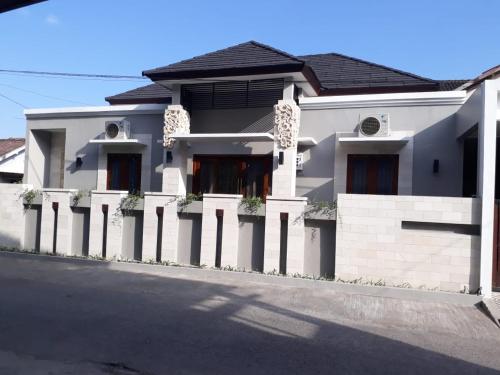 a white house with a fence on a street at Imperial Villa Syariah in Yogyakarta