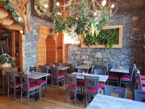 a restaurant with tables and chairs and a stone wall at Hotel de Geneve in Geneva