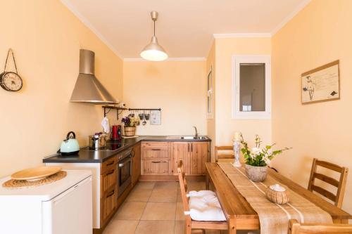 a kitchen with a wooden table and a counter top at Seaside Ipsos Apartment by Konnect in Ýpsos