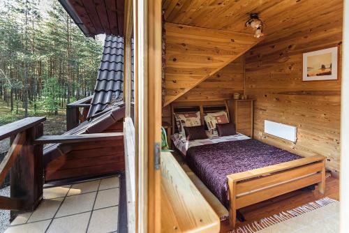 a bedroom in a log cabin with a bed at Svečių namai Smalvas in Visaginas