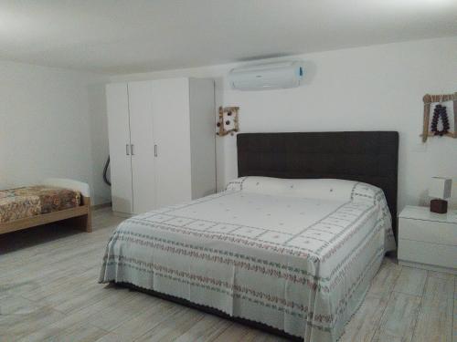 a bedroom with a bed and a white wall at Casa delle mimose in Varazze