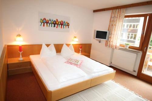 a bedroom with a white bed and a television at Apartment Anita in Ellmau