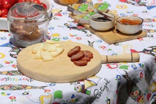 a table with cheese and bacon on a cutting board at Quinta de Lourosa in Lousada