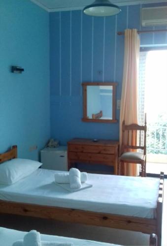 a bedroom with a bed with a mirror and a chair at Hotel Ionio in Katakolon