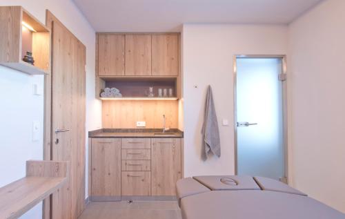 a small kitchen with wooden cabinets and a sink at Hapimag Ferienwohnungen Sonnleitn in Sonnenalpe Nassfeld