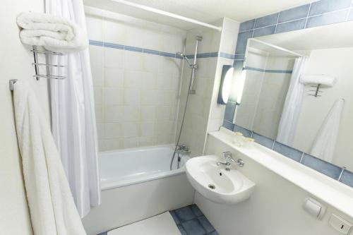 La salle de bains est pourvue d'une baignoire, d'un lavabo et de toilettes. dans l'établissement Campanile Hotel & Restaurant Delft, à Delft