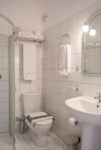 a white bathroom with a toilet and a sink at Studios Angeliki in Lassi