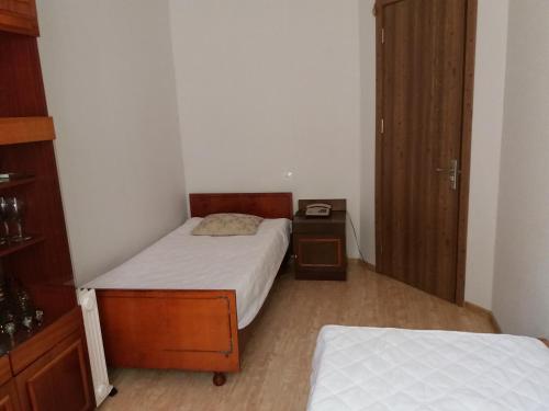 um pequeno quarto com 2 camas e uma mesa de cabeceira em Guest House Liana em Tbilisi