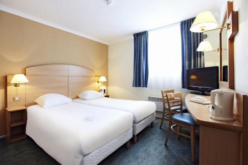 Habitación de hotel con cama, escritorio y TV. en Campanile Hotel & Restaurant Brussels Vilvoorde, en Vilvoorde