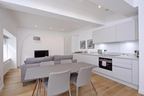 a kitchen and living room with a table and chairs at Destiny Scotland Apartments at Canning Street Lane in Edinburgh