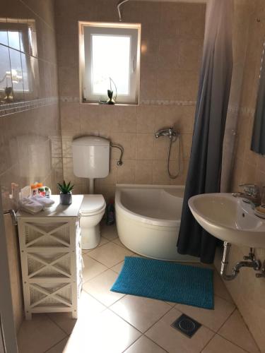ein Badezimmer mit einer Badewanne, einem WC und einem Waschbecken in der Unterkunft Apartments Angela in Primošten