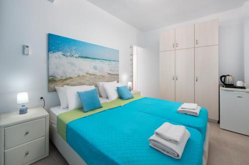 ein Schlafzimmer mit einem blauen Bett und Handtüchern darauf in der Unterkunft Elena in Symi