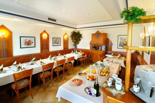 ein Restaurant mit weißen Tischen und Stühlen mit Essen darauf in der Unterkunft Gasthaus Kloibhofer in Neukirchen bei Lambach