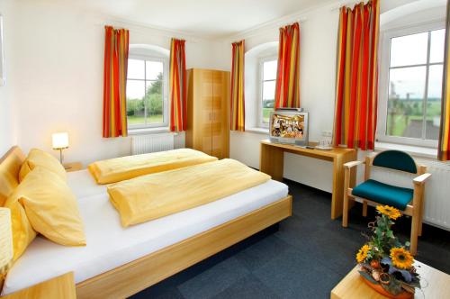 1 Schlafzimmer mit 2 Betten, einem Schreibtisch und einem Stuhl in der Unterkunft Gasthaus Kloibhofer in Neukirchen bei Lambach