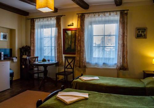a room with two beds and a table and a window at Lublin Apartaments in Lublin