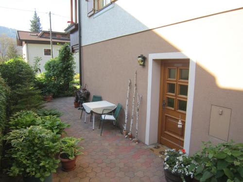 a patio with a table and chairs next to a building at Gästehaus Struggl in Steindorf am Ossiacher See