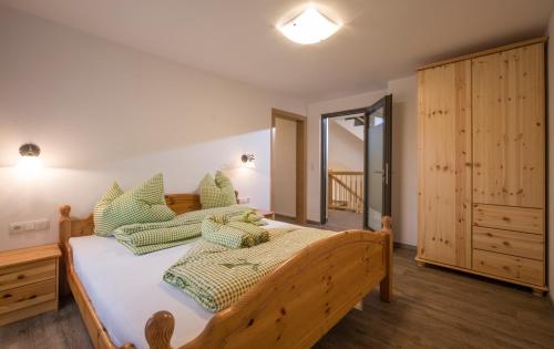1 dormitorio con cama de madera y almohadas verdes en Ferienwohnung Lederer en Söll