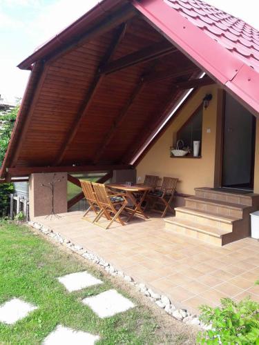 un patio con tavolo e sedie sotto un tetto di apartman-bartko a Banská Štiavnica