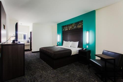 a bedroom with a bed and a desk and a chair at Palacio Royale Inn Boutique Katy in Katy