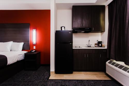 a hotel room with a bed and a kitchen at Palacio Royale Inn Boutique Katy in Katy
