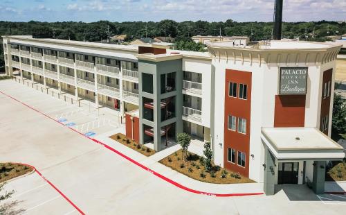 an overhead view of a building with a parking lot at Palacio Royale Inn Boutique Katy in Katy