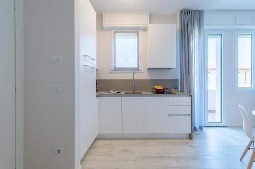 a kitchen with white cabinets and a sink at Appartamento Valeria by Wonderful Italy in Sirmione