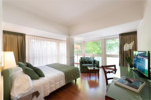 فندق باركيتا إكسلزيور في كومو: غرفة نوم مع سرير وغرفة معيشة