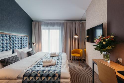 a hotel room with a large bed and a television at Avena Boutique Hotel by Artery Hotels in Krakow