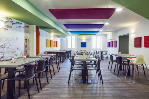 a dining room with tables and chairs and colorful walls at ibis Styles Marseille Vieux Port in Marseille