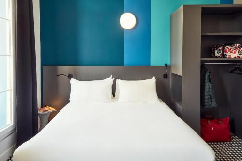 a large white bed in a room with a blue wall at ibis Styles Marseille Vieux Port in Marseille