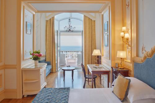 a hotel room with a bed and a desk and a table at Grand Hotel Excelsior Vittoria in Sorrento