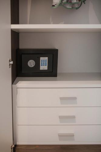 a clock sitting on top of a white dresser at Residenza Angelica in Lazise