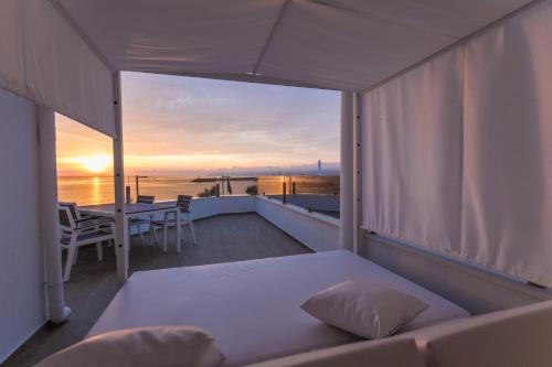 a balcony with a bed and a view of the ocean at Apartamentos Ses Roquetes in Can Picafort