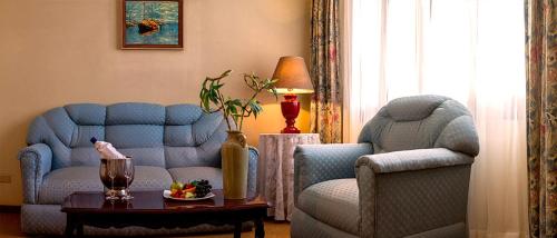 a living room with two blue chairs and a table at Gran Hotel Ambassador in Cochabamba
