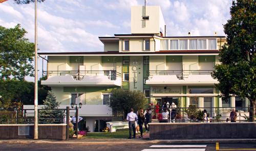 a large yellow building with people standing outside of it at Hotel Villa Chiara in Terracina
